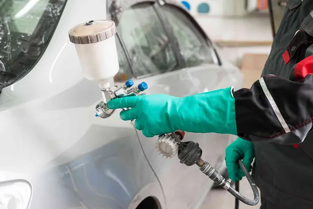 Automobilio dažymas Vilkaviškyje – meistras profesionaliu dažymo pistoletu dažo automobilio kėbulą autoservise.